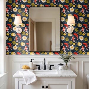 May include: A bathroom vanity with a white marble countertop, a rectangular sink, and a black faucet. Above the vanity is a rectangular mirror flanked by two white wall sconces. The wall features wallpaper with red koi fish and white water lilies.