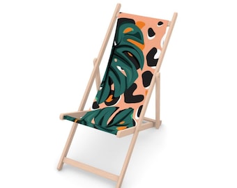 Puede incluir: Una silla plegable de madera con un asiento de tela estampado en rosa, verde y negro. El patrón presenta grandes hojas tropicales y formas abstractas.