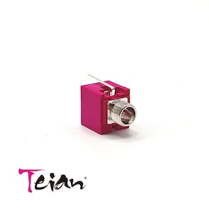 May include: A pink plastic connector with a silver metal jack. The connector has a small metal tab on the side.