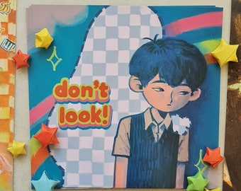 May include: A square art print featuring a stylized illustration of a person with blue hair and a blue vest. The text "don't look!" is in orange and yellow. The print is surrounded by colorful origami stars.