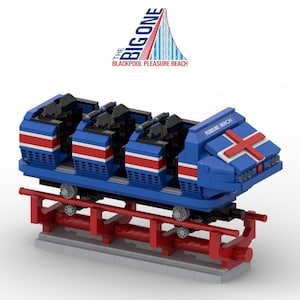 Könnte beinhalten: Blaues und rotes Modell eines Achterbahnwagens mit weiß gestreiften Details. Der Wagen steht auf einer roten Schiene. Über dem Wagen steht der Text "The Big One" und "Blackpool Pleasure Beach".