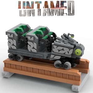 Könnte beinhalten: Ein graues und grünes Lego-Modell eines Wagens mit einem großen Auge an der Vorderseite. Der Wagen steht auf einem braunen Holzgleis. Der Text "Untamed" ist in Schwarz auf weißem Hintergrund über dem Wagen gedruckt.