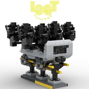 May include: A black and gray Lego model of a roller coaster car with four seats. The car is labeled "Lost Gravity" and has a black and yellow track.