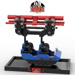 May include: A blue and black Lego model of a roller coaster train with red track supports. The train has a black base with the words "Iron Dragon" in red.