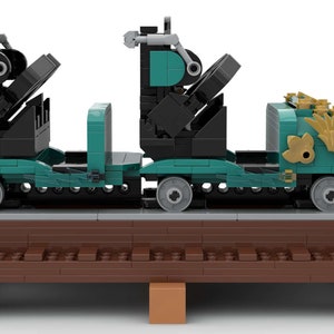 K&ouml;nnte beinhalten: Ein t&uuml;rkisfarbener und schwarzer Lego-Zugwagen mit goldenen Akzenten. Der Wagen hat zwei Sitze und steht auf einem braunen Gleis.