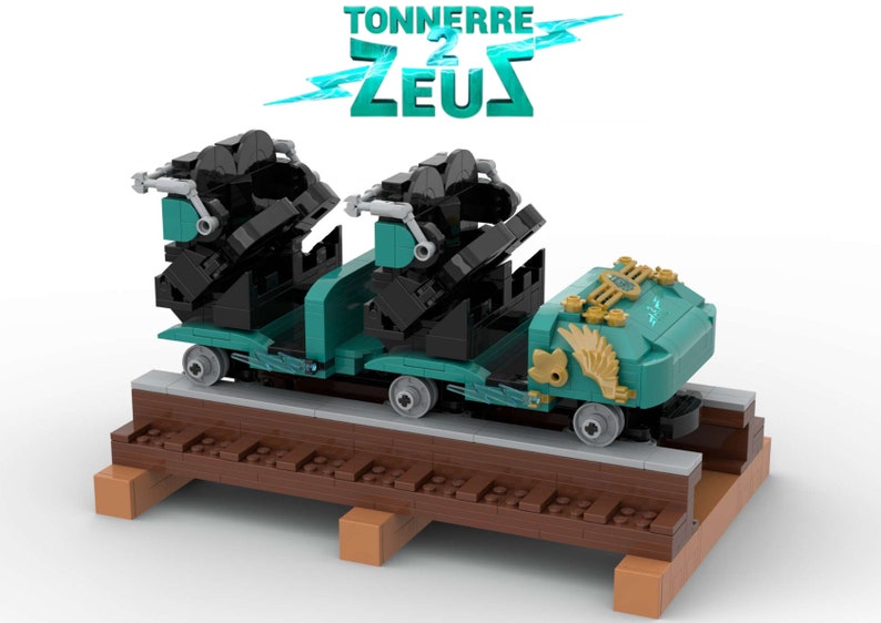 K&ouml;nnte beinhalten: Ein Lego-Modell eines Achterbahnzugs mit zwei schwarzen Sitzen und einem t&uuml;rkisfarbenen und goldenen Wagen. Der Wagen hat einen Blitz und Fl&uuml;gel an der Seite. Der Zug befindet sich auf einem Holzgleis. Der Text "TONNERRE 2 ZEUS" befindet sich &uuml;ber dem Zug.