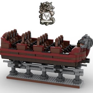 May include: A red and brown Lego model of a roller coaster car with a gray, sculpted dragon head at the back. The car is on a gray track and has a brown base.