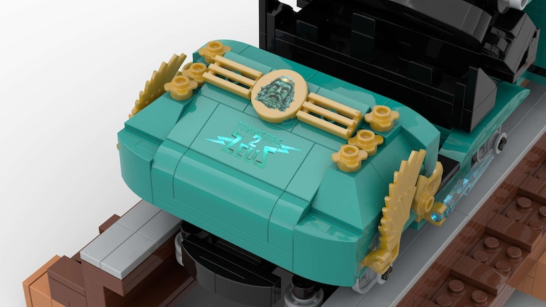 K&ouml;nnte beinhalten: Eine t&uuml;rkisfarbene Lego-Zuglokomotive mit goldenen Akzenten und dem Schriftzug "Thunderbolt Zeus" auf der Seite. Die Lokomotive hat ein goldenes Zahnrad an der Seite und ein goldenes Gesicht mit Bart an der Vorderseite.