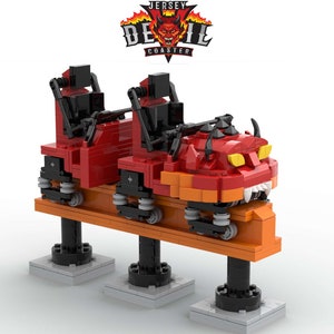 May include: A red and orange Lego model of a roller coaster car with a devil head design. The car is on a track and has two seats. The car is labeled "Jersey Devil Coaster".