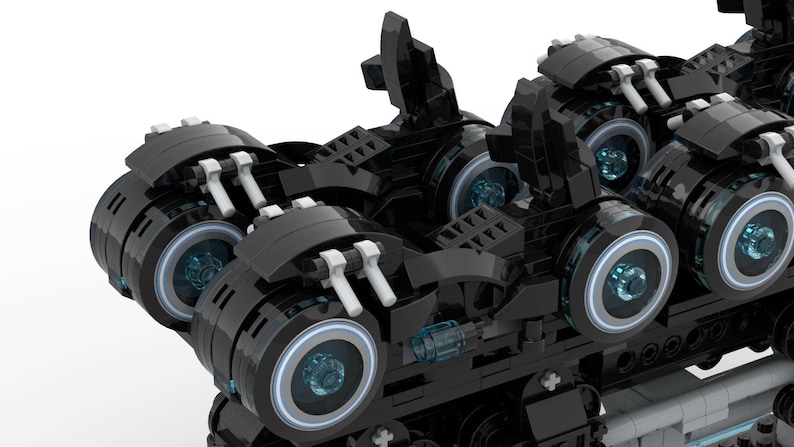 May include: A black and silver toy vehicle with multiple wheels and blue glowing lights. The vehicle has a futuristic design and is made of plastic.
