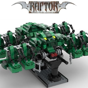 May include: A green and black Lego model of a roller coaster train called "RAPTOR". The train has six seats and is on a track.