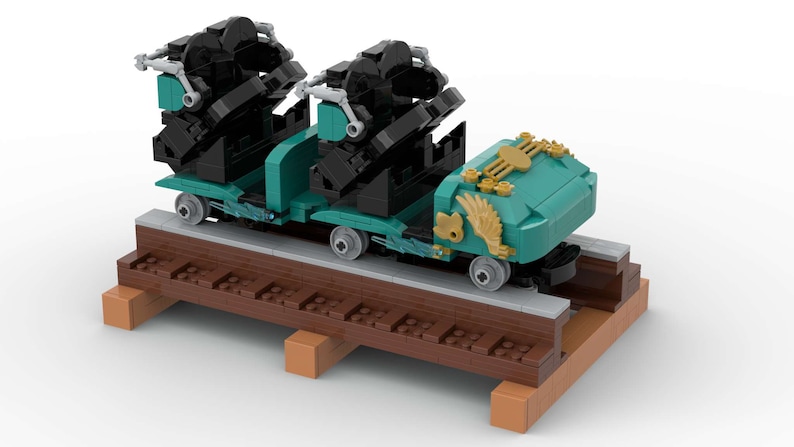 K&ouml;nnte beinhalten: Ein t&uuml;rkisfarbener und schwarzer Lego-Achterbahnwagen mit goldenen Akzenten. Der Wagen befindet sich auf einer braunen Holzschiene.