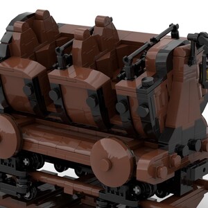 Puede incluir: Un modelo LEGO de vag&oacute;n de mina marr&oacute;n y negro con cuatro asientos. El vag&oacute;n est&aacute; en una v&iacute;a y tiene una linterna en la parte trasera.