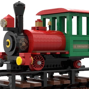 May include: A red and green Lego train engine with black wheels and a black smokestack. The engine has a yellow headlight and a sign that reads "The Little Red Caboose Railroad". The caboose is green and has a sign that reads "U.R. Courageous".