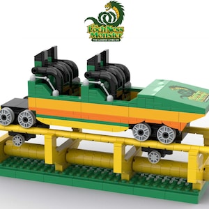 Puede incluir: Un modelo de montaña rusa de Lego verde, naranja y amarillo con las palabras "The Loch Ness Monster" y "The Legend Lives On" en el lateral. El coche está en una vía amarilla con soportes verdes.