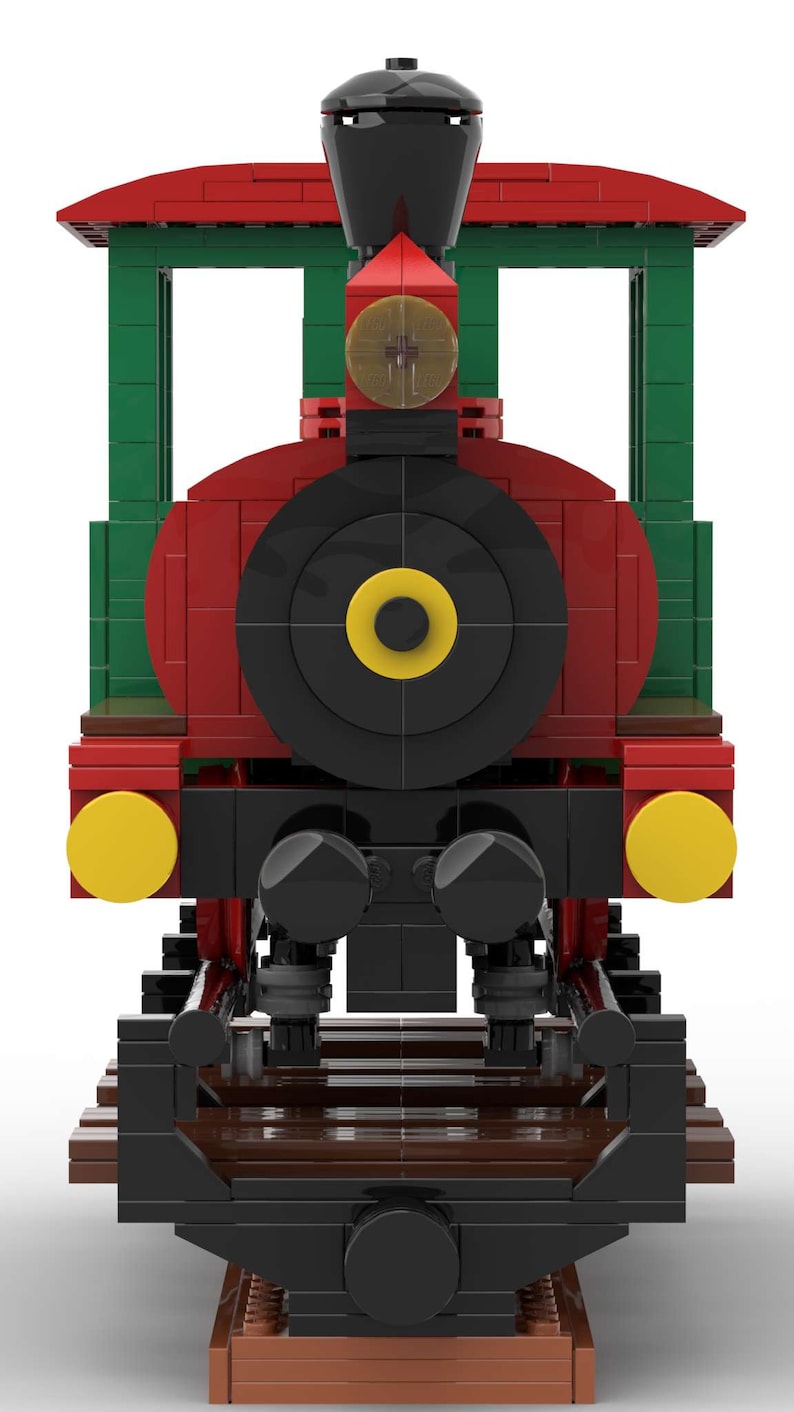 May include: A red, green, and black toy train engine with yellow headlights and a black wheel. The train is on a brown track.