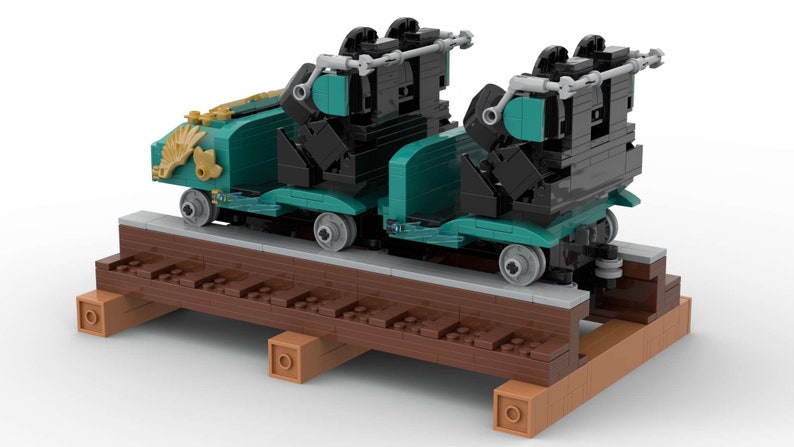 K&ouml;nnte beinhalten: Zwei t&uuml;rkisfarbene und schwarze Lego-Z&uuml;ge mit goldenen Akzenten auf einem braunen Holzgleis. Die Z&uuml;ge haben ein detailliertes Design und sind bereit, in einem Lego-Zugset verwendet zu werden.