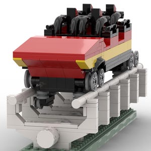 May include: A red and yellow Lego roller coaster car with black seats and wheels, on a white and grey track with green base plates.