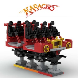 Puede incluir: Un vagón de tren Lego rojo y negro con un frente amarillo y ruedas negras. El vagón está en una vía y tiene un letrero que dice "KARACHO" encima.