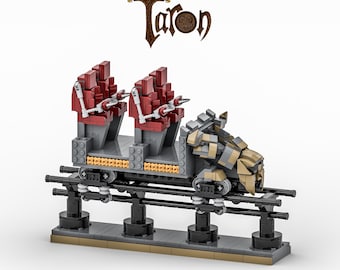 May include: A brick-built model of a roller coaster car featuring the text Taron at the top. The car has two rows of red seats with white restraints, a gray chassis, and a tan and gray front section, all mounted on a black track base.