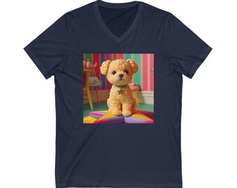 May include: A navy blue v-neck t-shirt with a graphic of a small, light brown dog sitting on a colorful star-shaped cushion. The dog is wearing a green collar with a gold star charm.