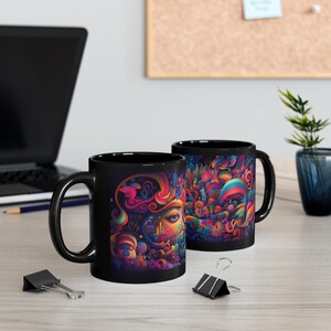 May include: Two black ceramic mugs with colorful abstract designs. The designs feature swirling patterns, a human eye, and a variety of shapes and colors.