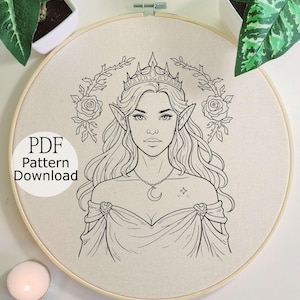 May include: Embroidery hoop with a detailed line drawing of an elven woman wearing a crown and a crescent moon necklace. The text "PDF Pattern Download" is visible. The design is surrounded by roses and foliage.