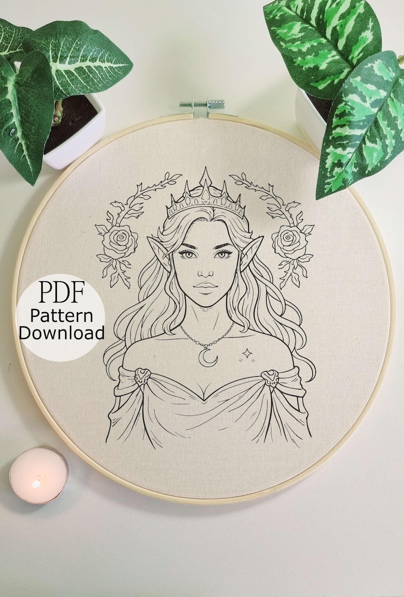 May include: Embroidery hoop with a detailed line drawing of an elven woman wearing a crown and a crescent moon necklace. The text "PDF Pattern Download" is visible. The design is surrounded by roses and foliage.