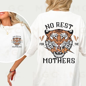 May include: White t-shirt with a tiger graphic and the text "No Rest For The Mothers" printed on the back. The front of the shirt has a smaller tiger graphic and the text "No Rest For The Mothers".