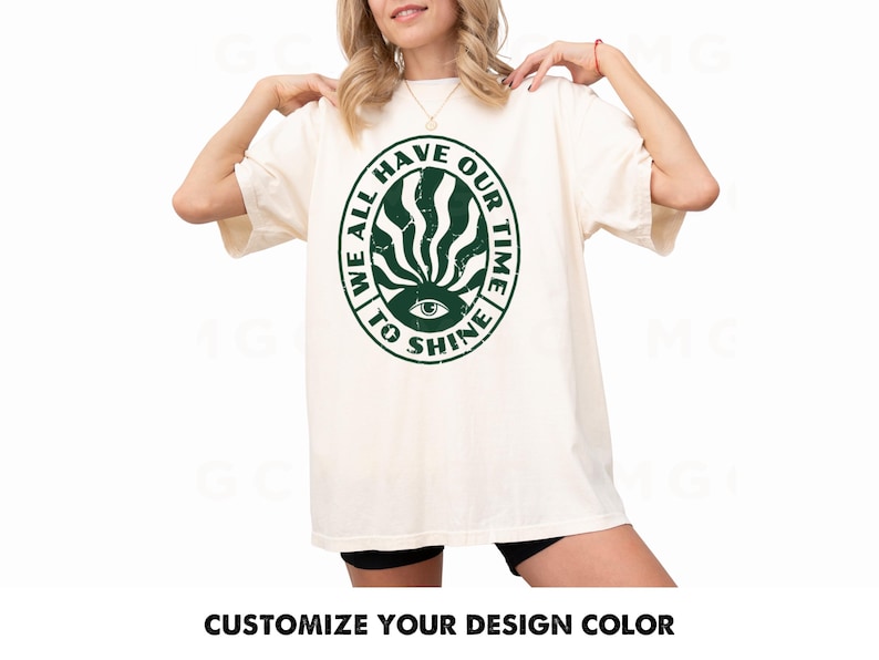 May include: A white t-shirt with a green circle graphic that says "We all have our time to shine".