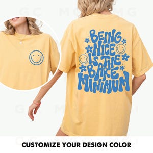 May include: Yellow t-shirt with blue text that reads "Being Nice Is The Bare Minimum" with smiley faces.