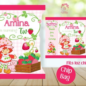 May include: Pink chip bag design with a Strawberry Shortcake theme. The bag features the name "Amina" and the phrase "is turning two." Illustrations include strawberries, a character, and the text "Thank you for coming."