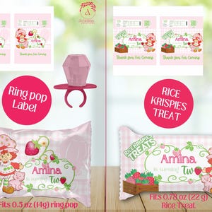 May include: Pink party favors featuring a strawberry-themed design. The image includes ring pop labels, ring pops, and Rice Krispies Treats. The text reads "Amina is turning Two" and "Thank you for coming."
