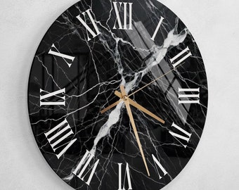 May include: A black and white marble clock with Roman numeral markings. The clock has gold hands and a black background.