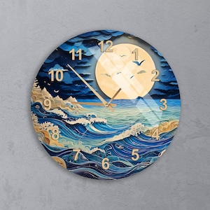 May include: A round wall clock featuring a stylized ocean scene with deep blue swirling waves, golden foam accents, and a large pale yellow moon in a dark sky. The clock face displays gold-colored numbers from 1 to 12 and thin gold clock hands.
