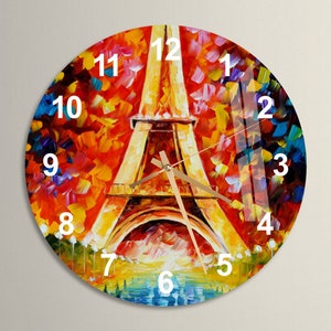 May include: A round wall clock with a colorful abstract painting of the Eiffel Tower. The clock face has Roman numeral hour markers and gold-colored hands.