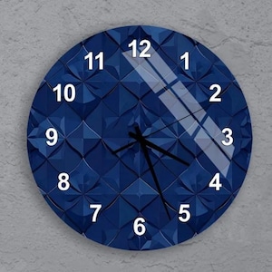 May include: A round, navy blue wall clock with a textured, geometric design. The clock face features white numerals and black hands. The clock is a decorative item for home decor.