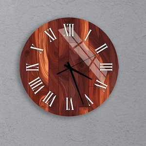 Peut inclure: Horloge murale ronde avec un motif de grain de bois. Le cadran de l'horloge présente des chiffres romains blancs et des aiguilles noires. L'horloge est fixée sur un mur gris.