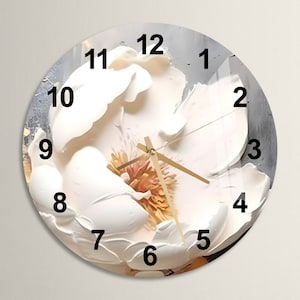 Puede incluir: Un reloj de flores blancas con agujas doradas y números negros. La esfera del reloj es un primer plano de una flor blanca con un centro amarillo.