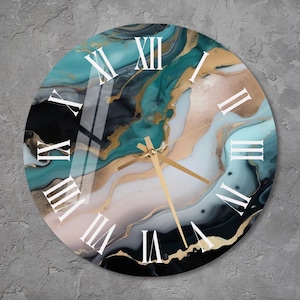 May include: A round clock with a teal, black, and gold abstract design. The clock face has Roman numeral markings.