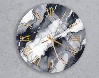 May include: Round wall clock with a marble design in shades of gray, white, and black. The clock features gold-colored Roman numerals and hands, creating a modern and elegant aesthetic. The clock is mounted on a gray wall.