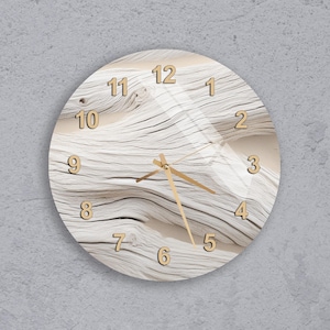 Puede incluir: Reloj de pared redondo con un diseño de veta de madera clara. La esfera del reloj presenta números y manecillas doradas, con una cubierta de vidrio transparente. El fondo tiene una apariencia natural y texturizada, creando una estética rústica.