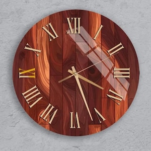 Peut inclure: Horloge murale ronde en bois avec un motif de grain de bois brun foncé. Le cadran de l'horloge comporte des chiffres romains et des aiguilles dorés. L'horloge est fixée sur un mur gris clair.