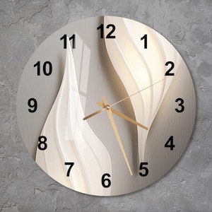 May include: A white and beige round clock with gold hands and black numbers. The clock face has a white abstract design with wavy lines.