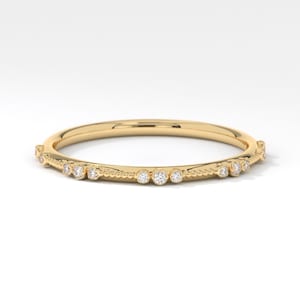 May include: A delicate gold band ring with a row of small diamonds set along the edge.