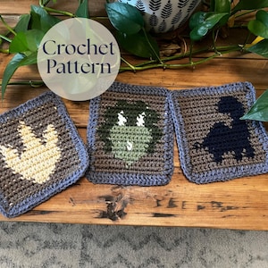 Può includere: Tre modelli di uncinetto quadrati con disegni di dinosauri. Ogni quadrato presenta una diversa silhouette di dinosauro nelle tonalità del marrone, verde e blu, con un bordo blu. Il testo "Crochet Pattern" è in un cerchio bianco.