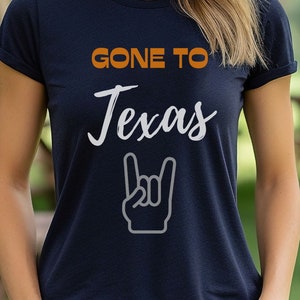 May include: A navy blue t-shirt with the text "GONE TO TEXAS" in orange and a white rock and roll hand gesture.