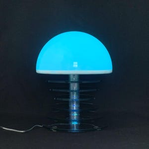 May include: A blue and white mushroom-shaped lamp with a clear acrylic base and a multi-colored LED light display.