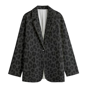 May include: A dark grey blazer featuring a black leopard print pattern. The blazer has a notched lapel, a single-button closure, and a front pocket. The interior lining is white.