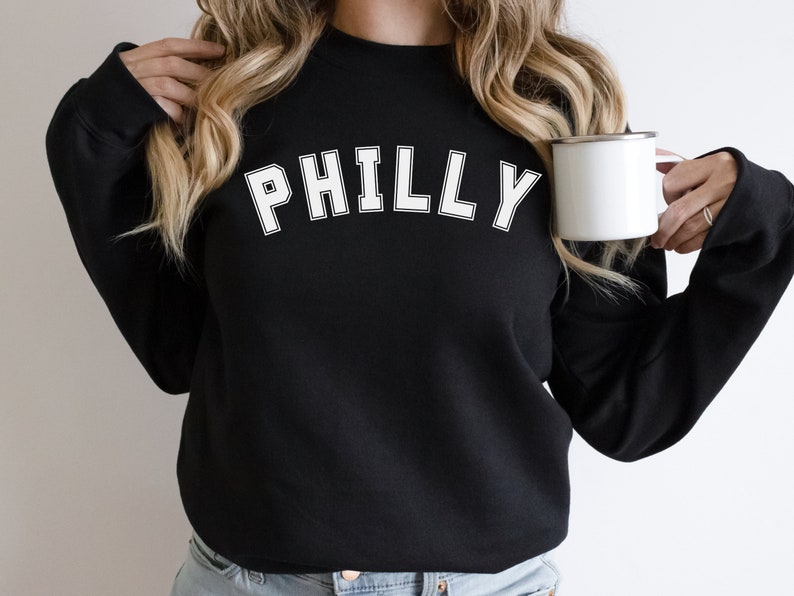May include: Black sweatshirt with white text that says "PHILLY" in a varsity style font.